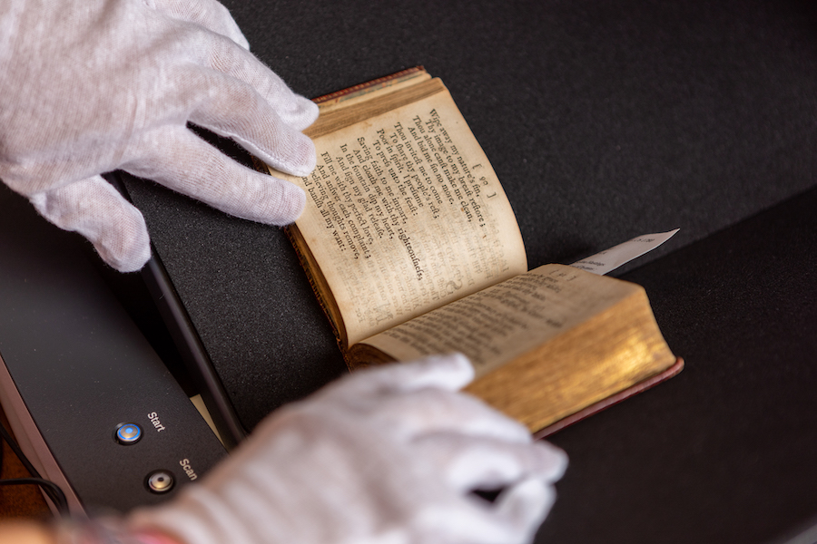 white gloves handling an old book