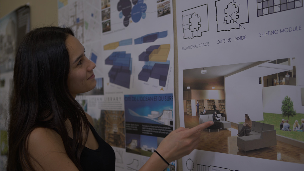 Student looking over a poster with interior design ideas