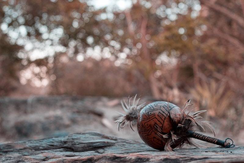 An African musical rattle resting on a rock