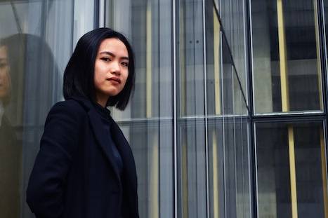 A female CBU student leaning on a wall