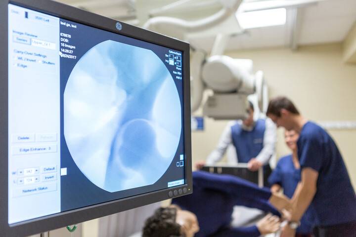 CBU students practicing with an x-ray machine on a medical model