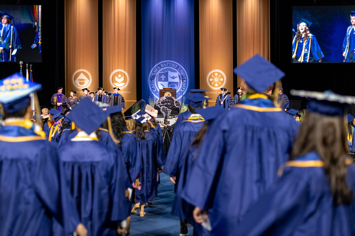 Graduates at Commencement watching the stage