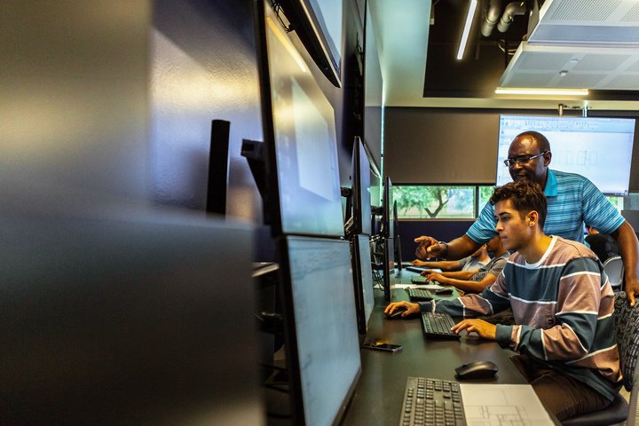Students working in computer lab with professor