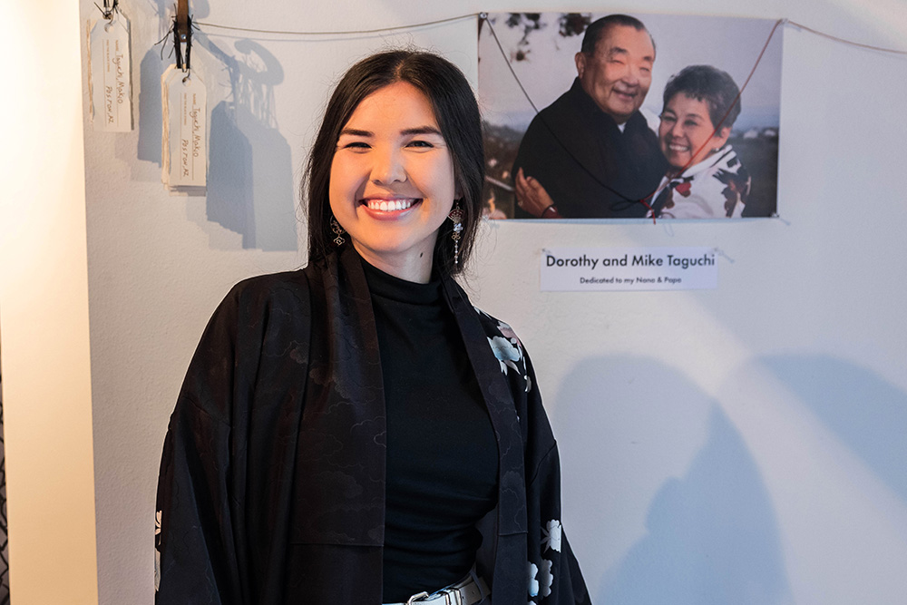 Woman standing in front of grandparents' photo