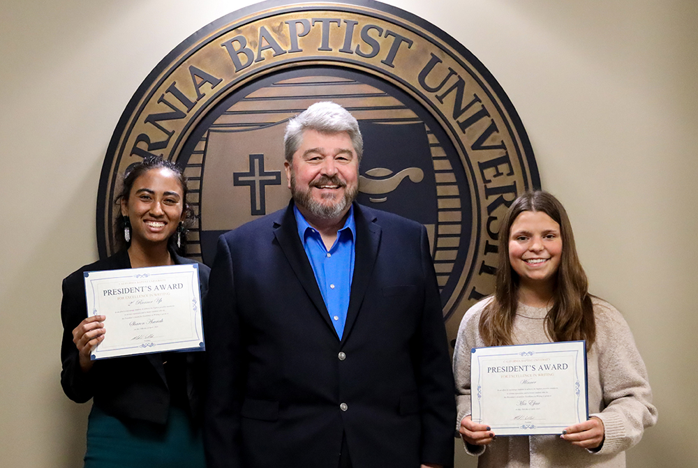 three people smile at camera