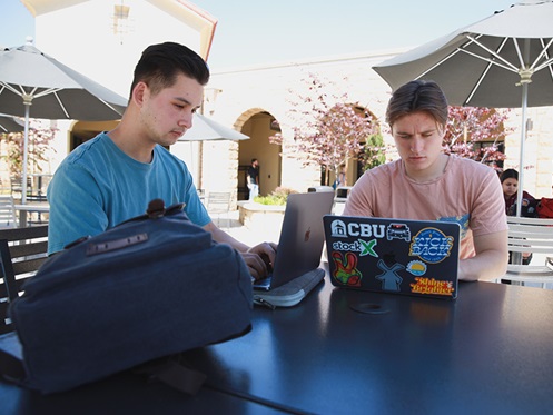 Students working on laptop in Lancer Plaza