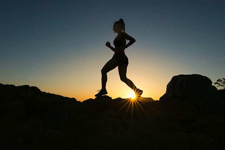woman running on rocky terrain 