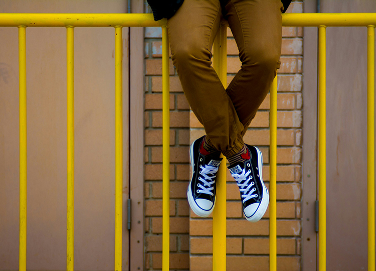 Student sitting on rail