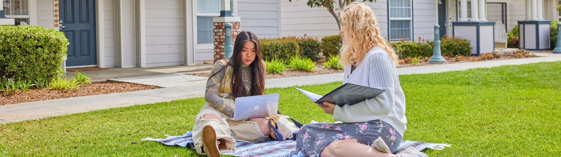 Students sitting on the lawn with papers