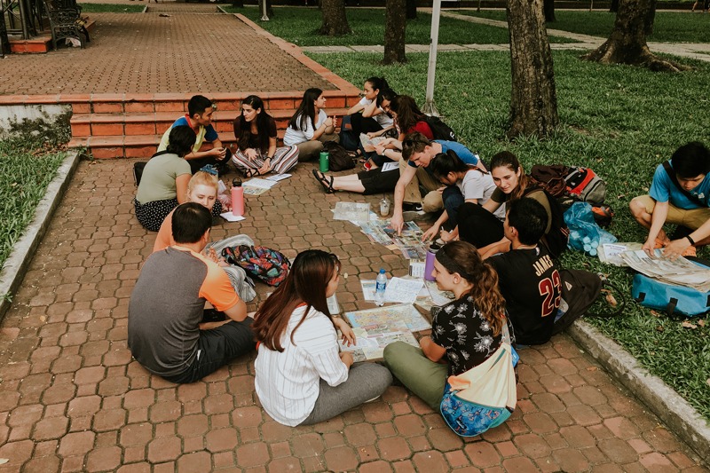 group of students sitting down on ground